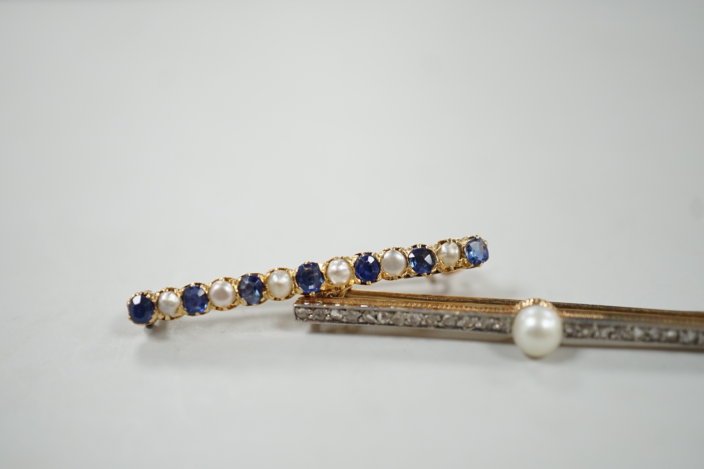 A 1920's yellow metal, cultured pearl and rose cut diamond set bar brooch, 47mm and a later yellow metal, split pearl and sapphire set bar brooch, gross weight 6.2 grams.